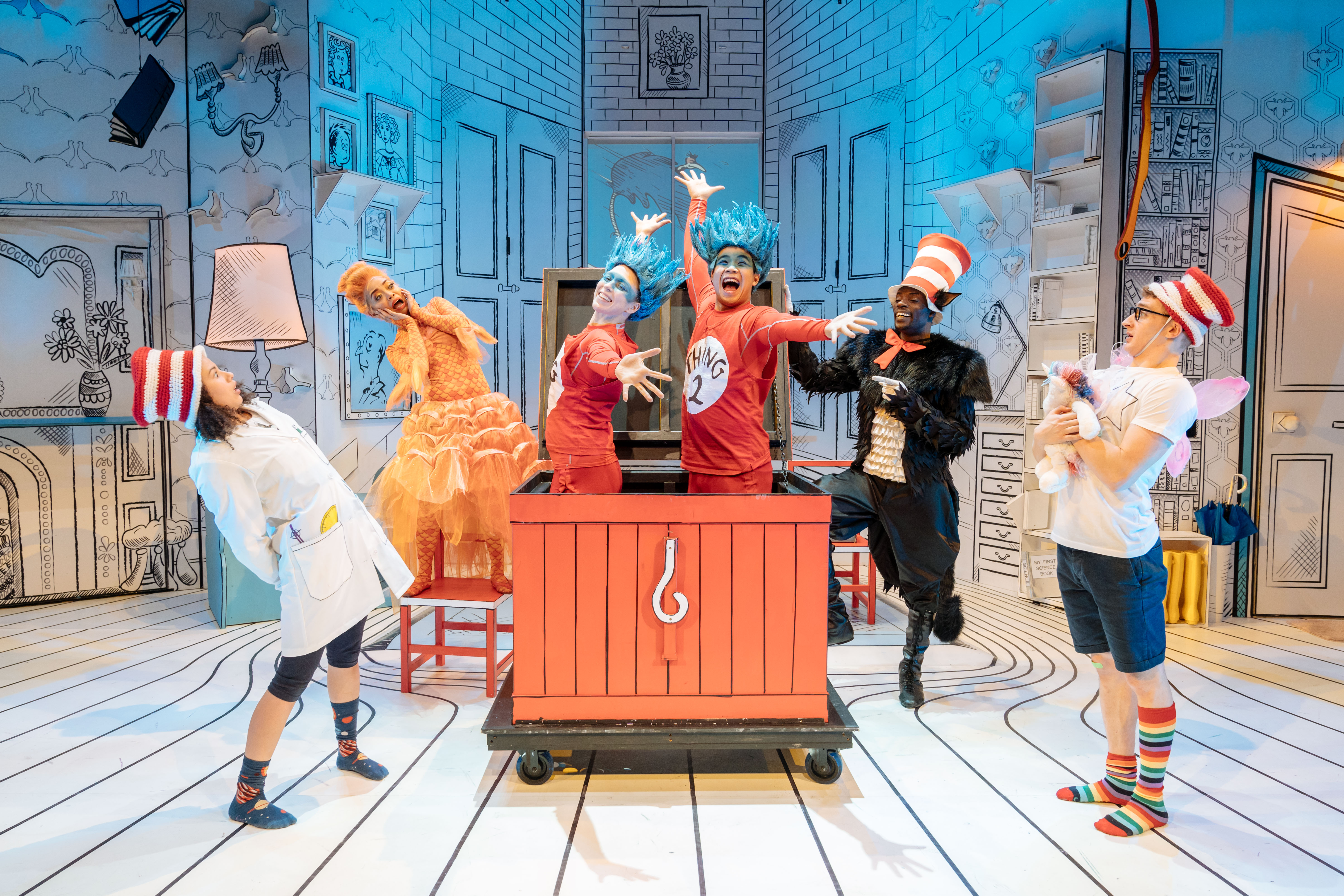 Production image from The Cat in the Hat. Sally, Fish, Cat and Boy exclaim as Thing 1 and Thing 2 appear from a red crate.