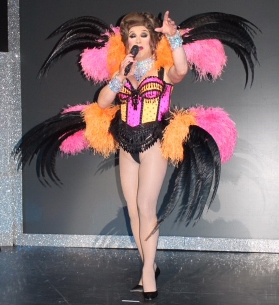 Ceri Dupree singing in a pink and orange burlesque outfit