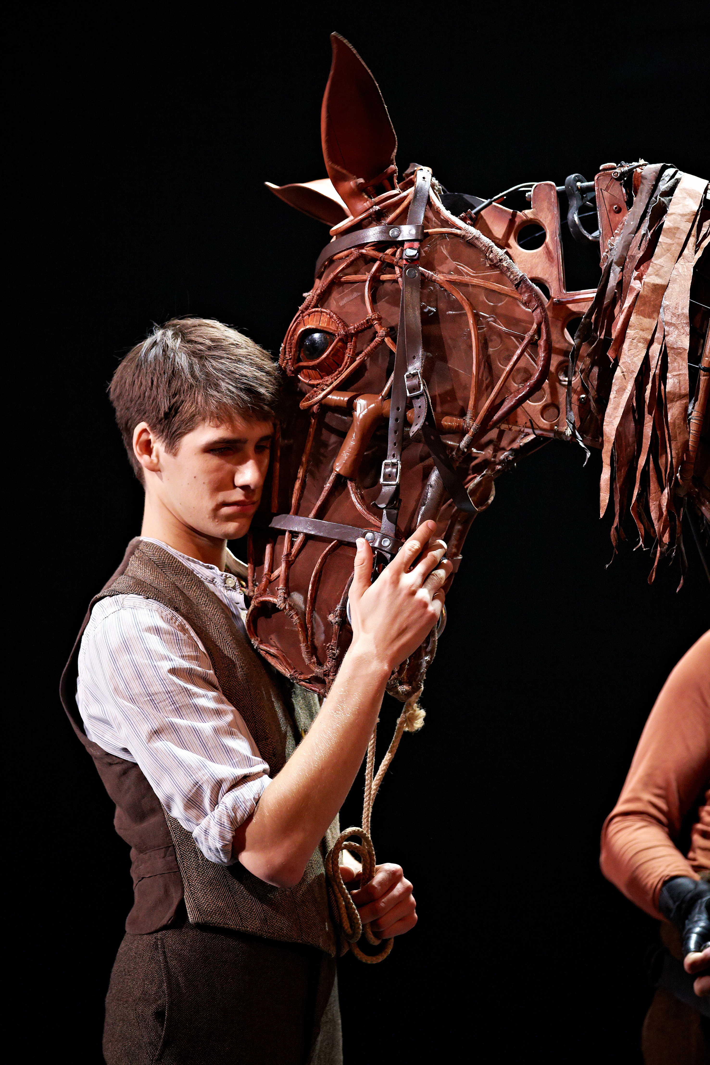 a chesnut horse affectionately touching its nose to the actors face.