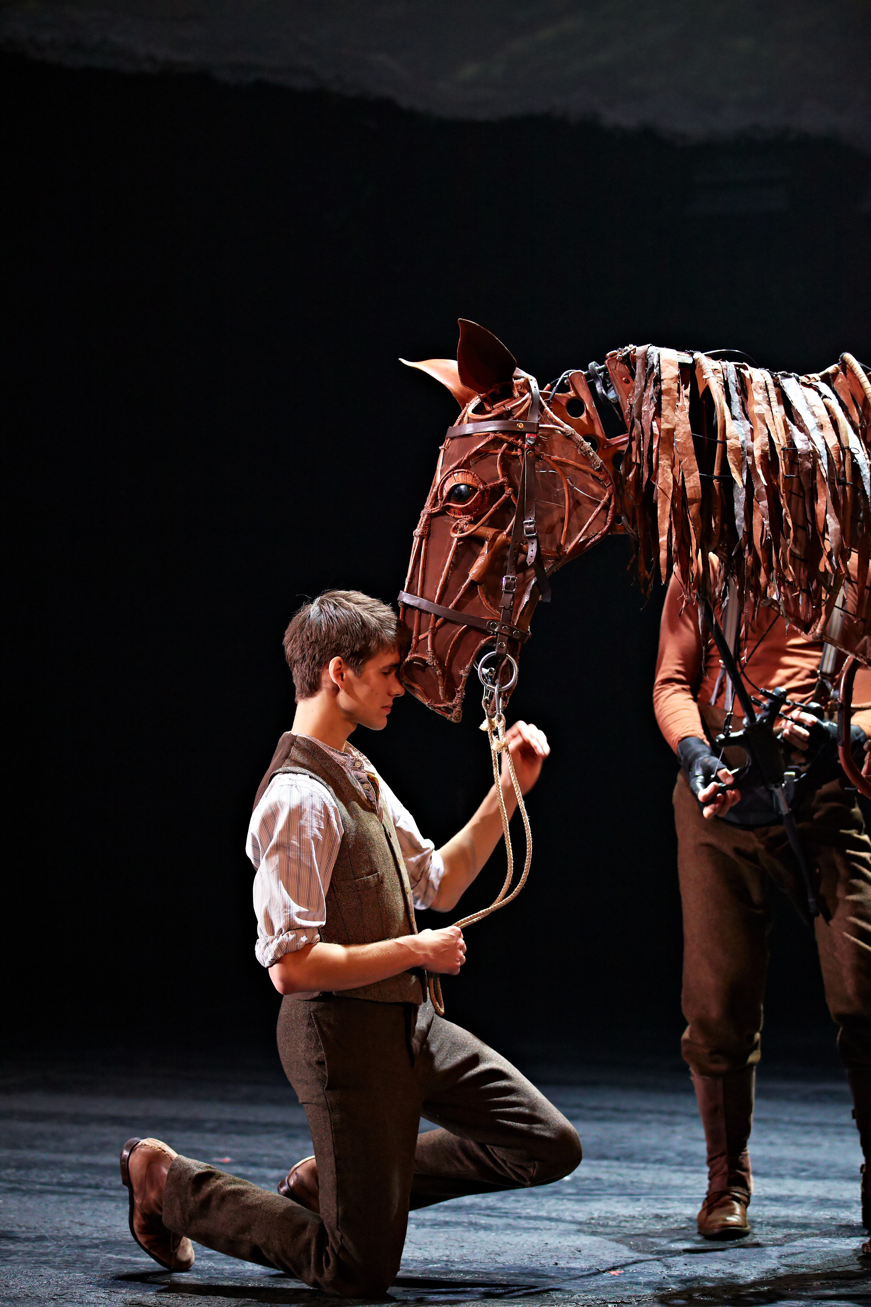 chesnut horse affectionately touching their nose to an actors forehead
