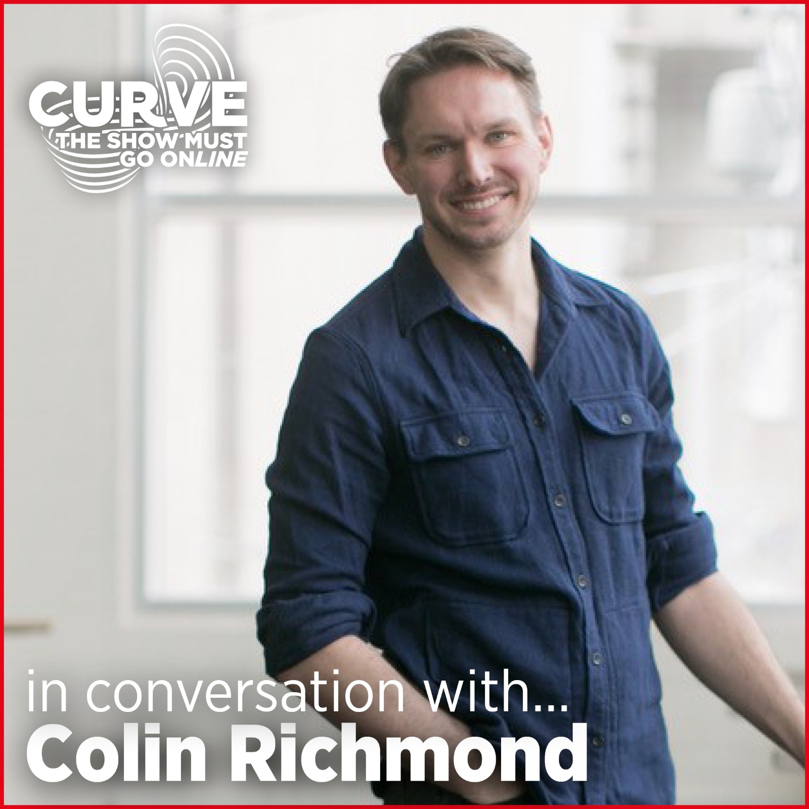 Colin Richmond smiles in a bright room, wearing a dark blue shirt.